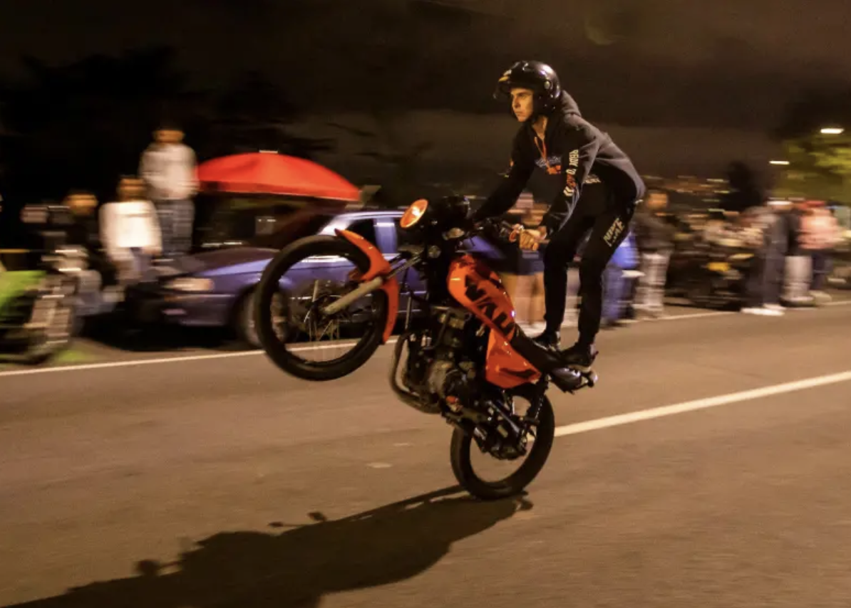 Motociclista realizando una pirueta en vía nocturna — Cerritos